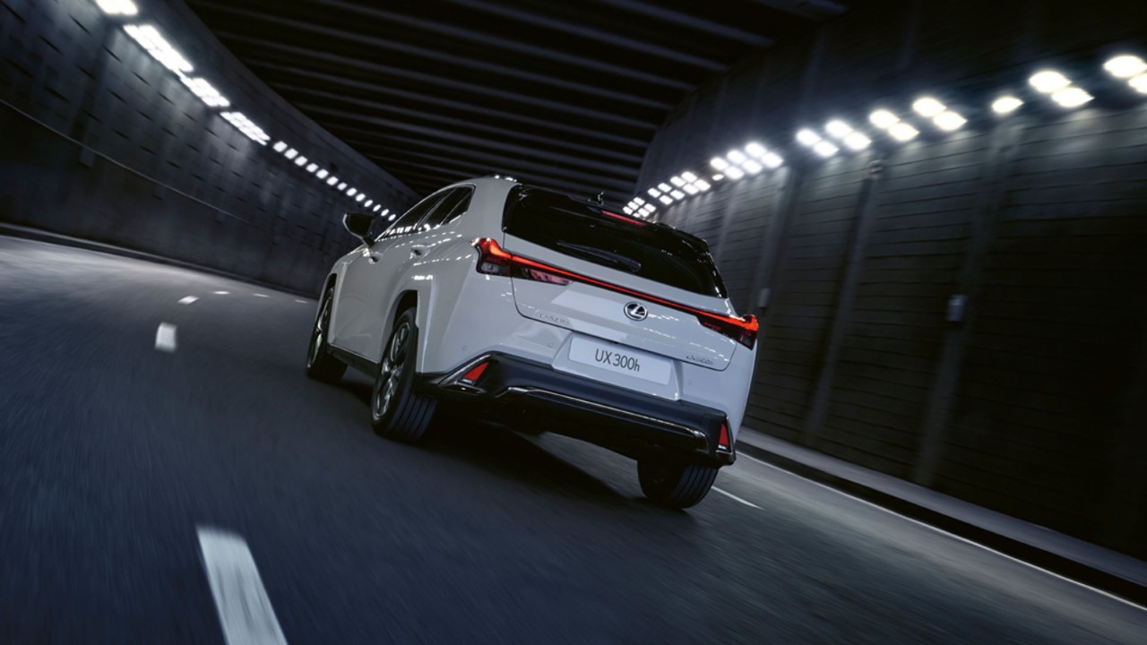 A white Lexus driving in a tunnel